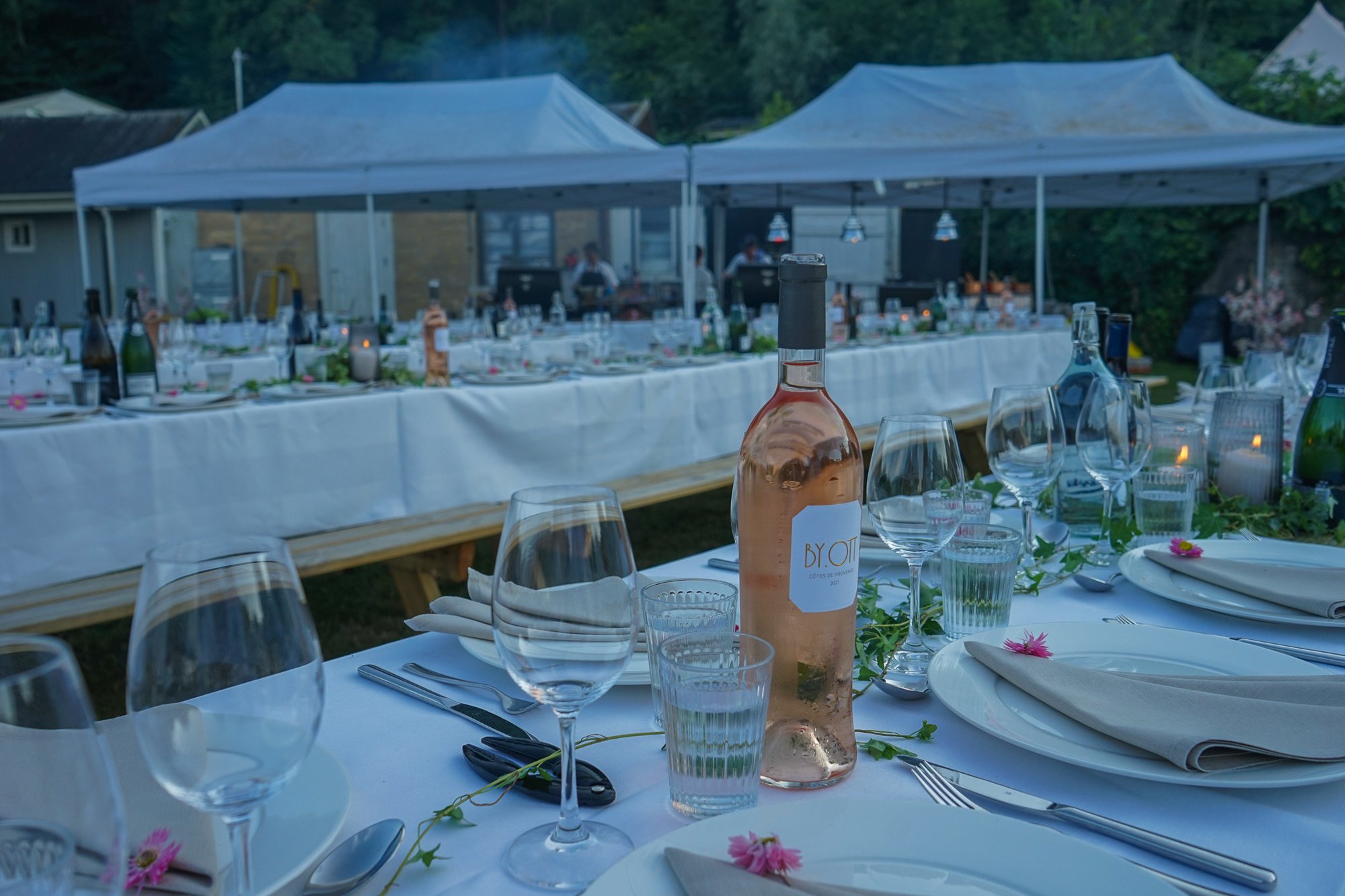 Long tables set for a party on a summer evening at Camp Ven
