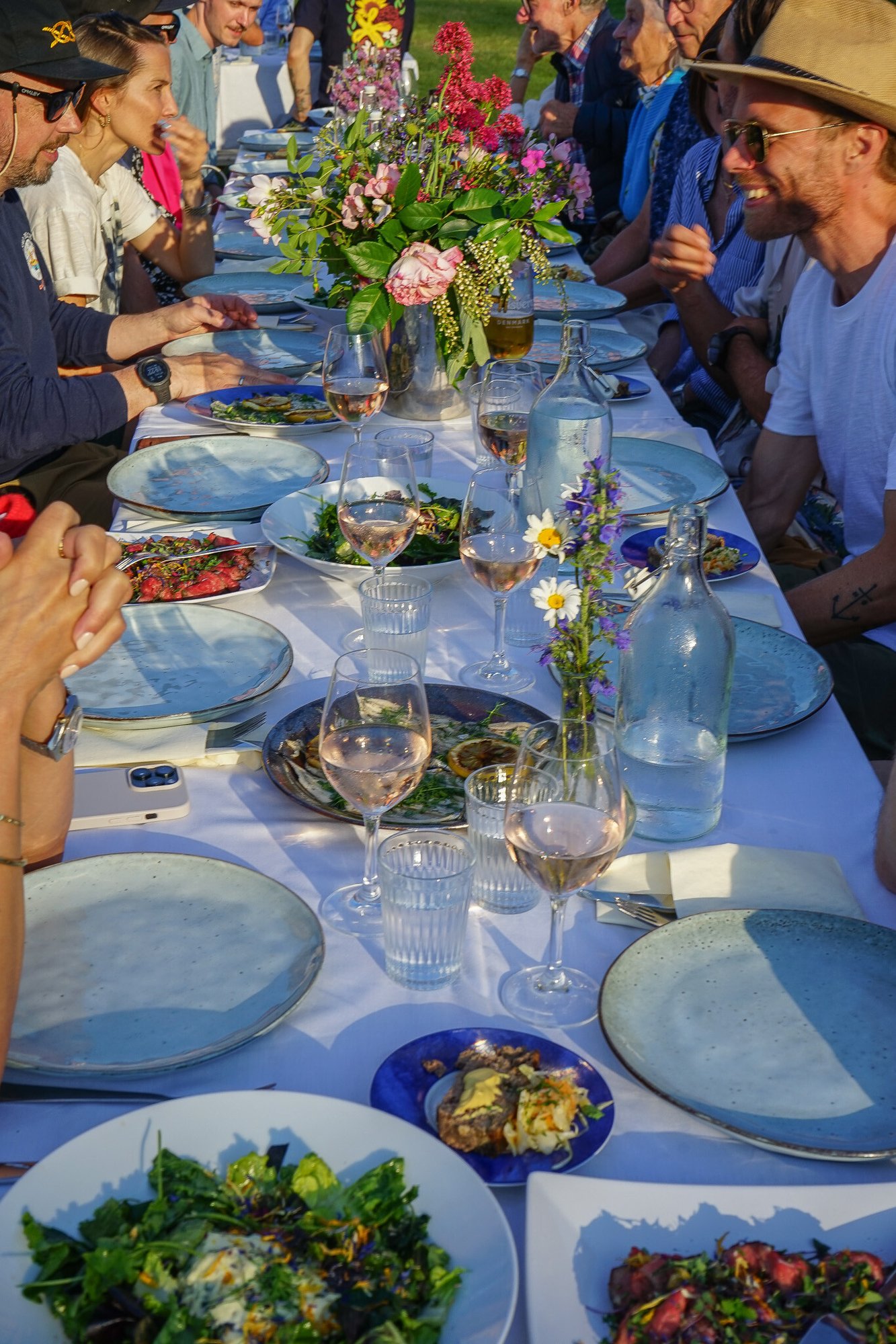 Härlig stämning bland kollegor vid långbord utomhus i kvällssol på Ven